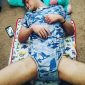 The baby outfit is on a Lazy Boy who is curled up on the ground.