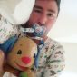 A Nipple Sucking Man is lying on his back like a baby while carrying the toy.