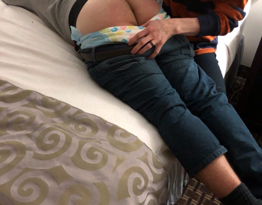 Adult Disgraceful Diapering the other man while he is lying on the bed and exposing his butt