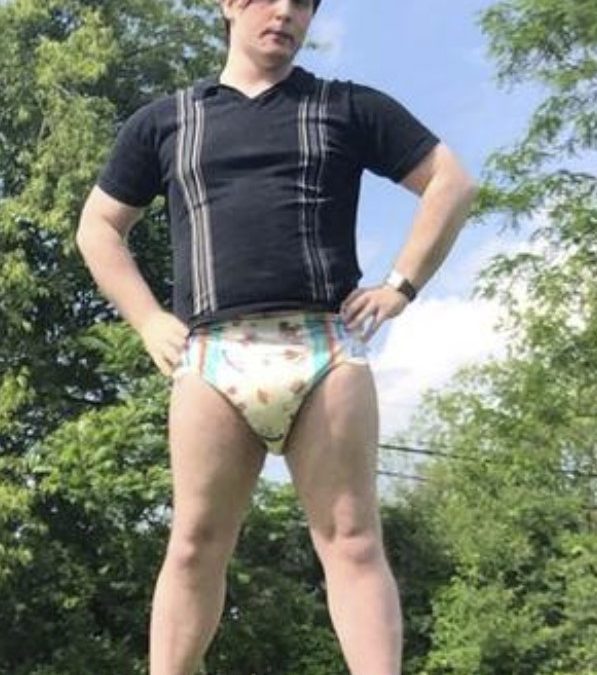 A Joke Diaper Man is standing for the photo shoot while donning a diaper, and he also has a job.