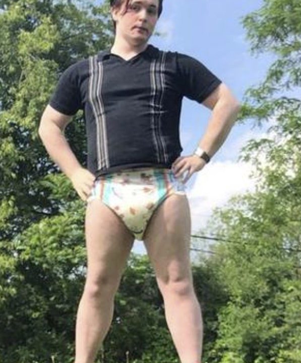 A Joke Diaper Man is standing for the photo shoot while donning a diaper, and he also has a job.